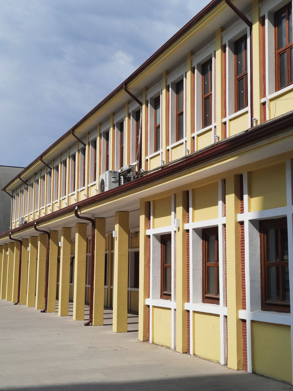 Facciata di un edificio scolastico con finestre e colonne.