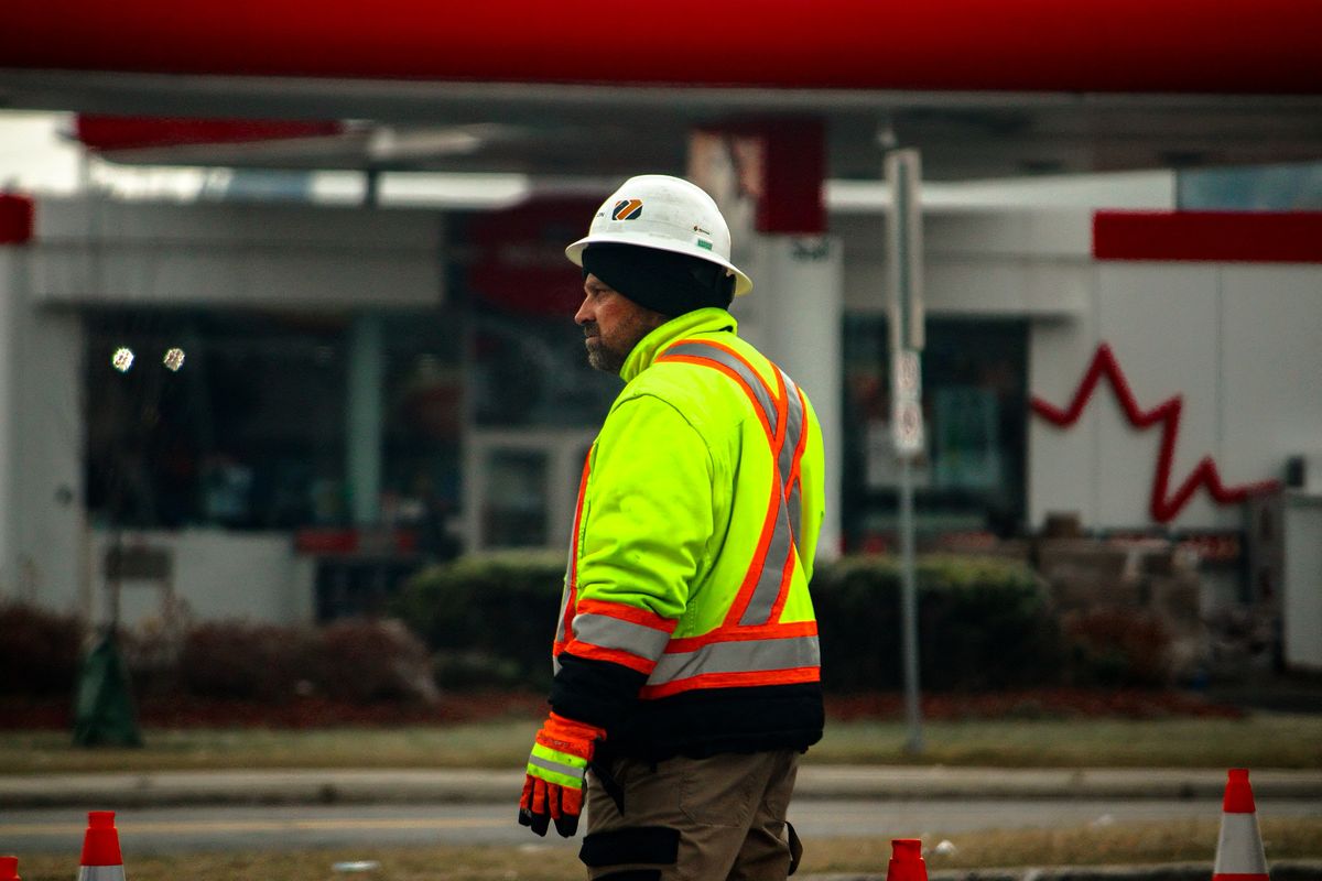 Un ouvrier en vêtements de haute visibilité sur un chantier de voirie.