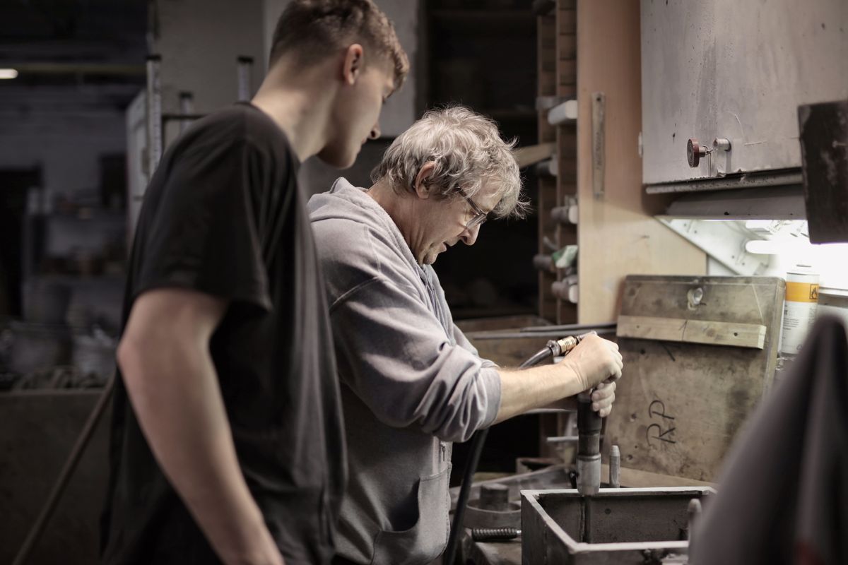 Deux personnes travaillent avec des outils à un établi.