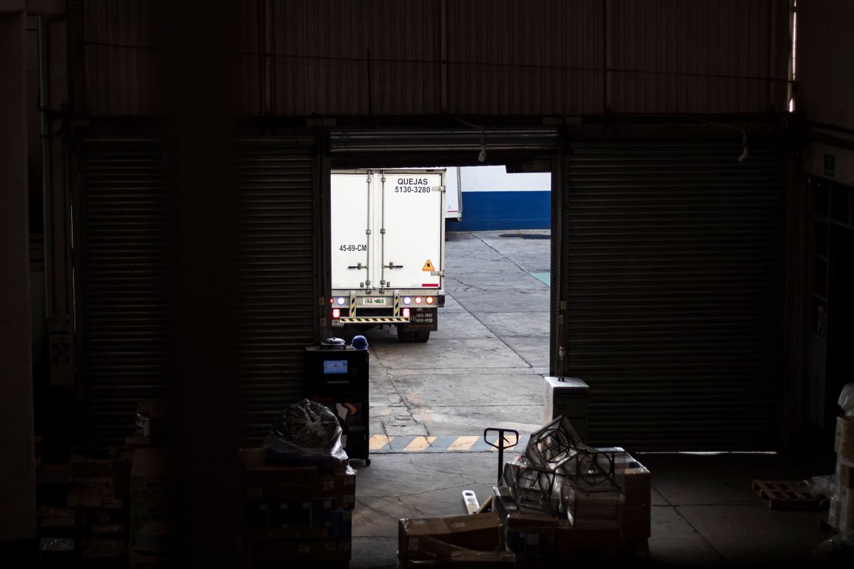 Uma carrinha branca sai da zona de cargas de um armazém.