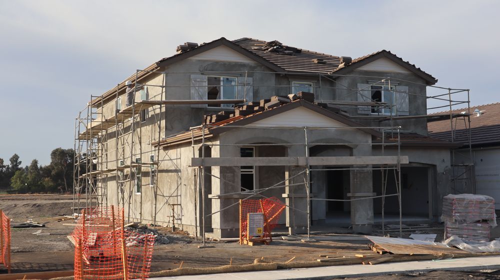 A house under construction surrounded by scaffolding.