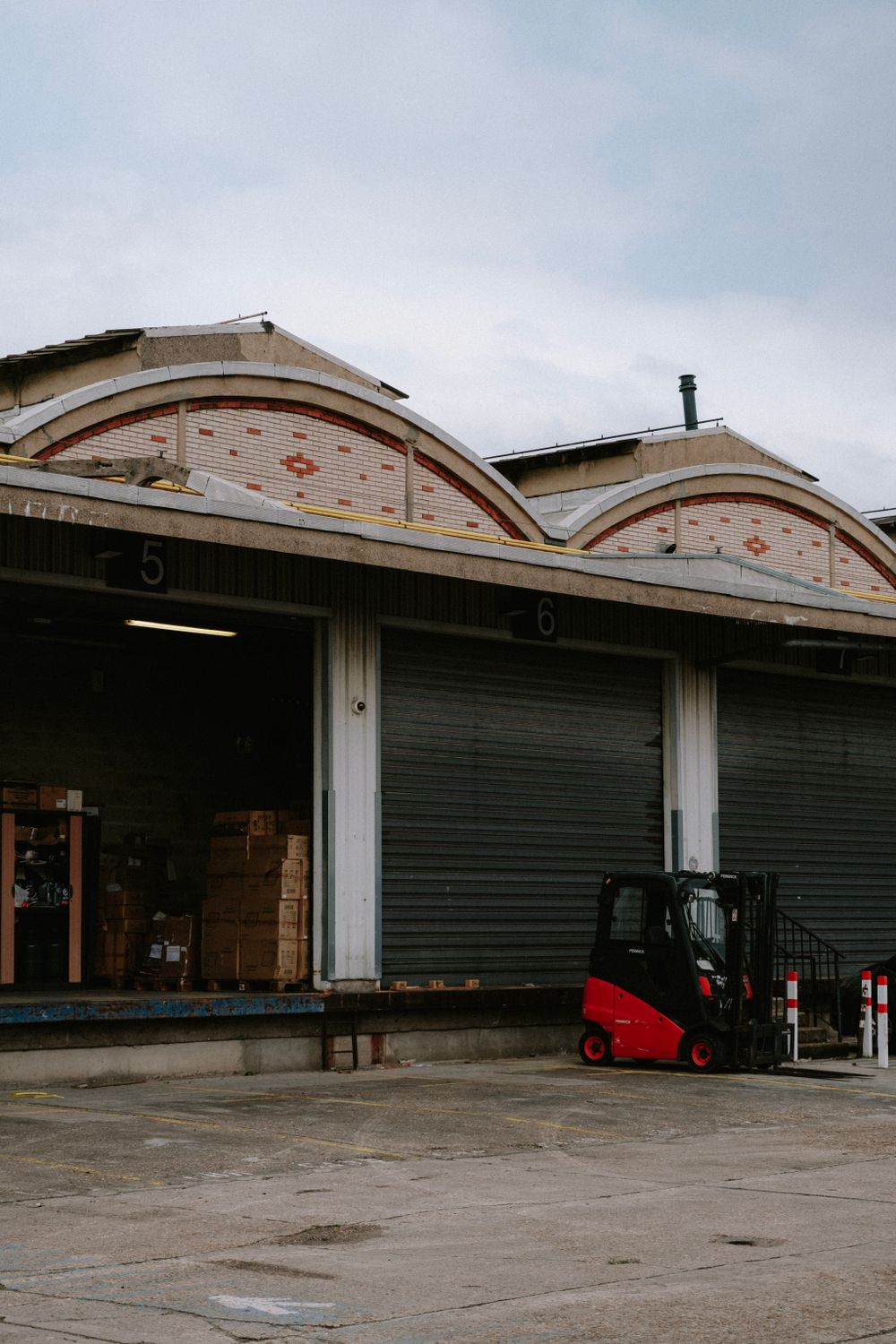 A red forklift parked at a warehouse loading dock.