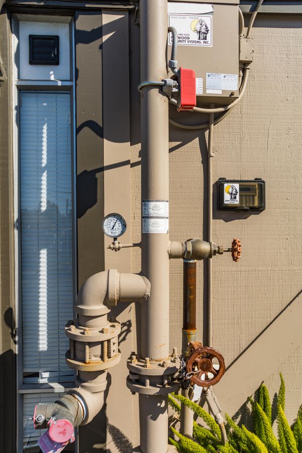 Exterior pipework with valves and a pressure gauge.