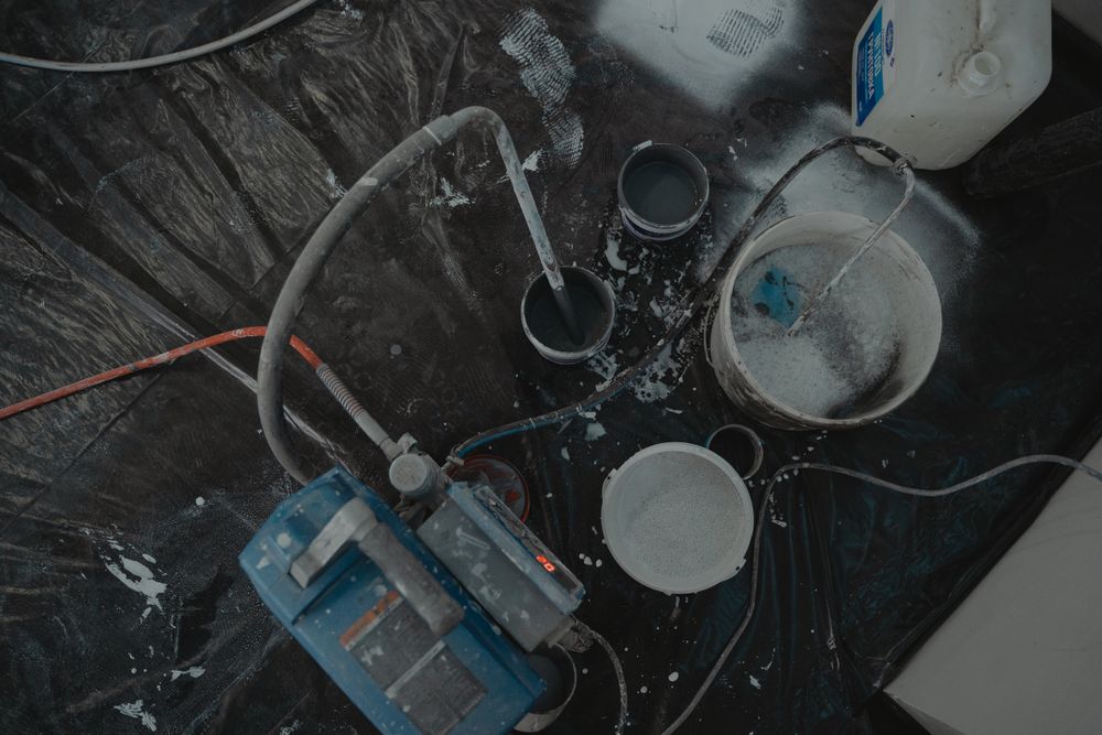 Recipientes, tubos e equipamento de preparação de tinta numa oficina.