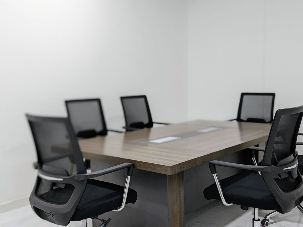 Une table et des chaises dans une salle de réunion vide.
